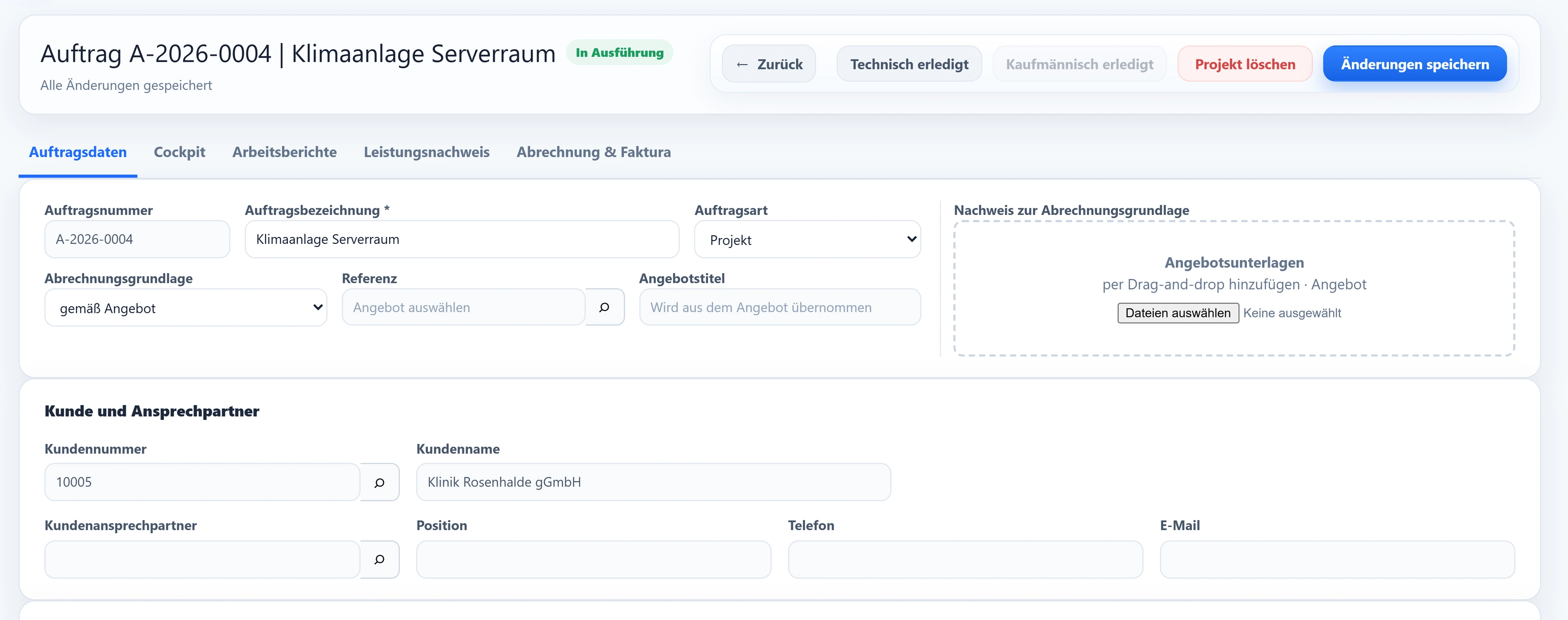 Der Auftrag A-2026-0004 „Klimaanlage Serverraum“ im Modul Projektaufträge: Auftragsnummer, Auftragsart Projekt, Abrechnungsgrundlage gemäß Angebot und der Kunde 10005 Klinik Rosenhalde gGmbH, dazu die Reiter Auftragsdaten, Cockpit, Arbeitsberichte, Leistungsnachweis und Abrechnung & Faktura.